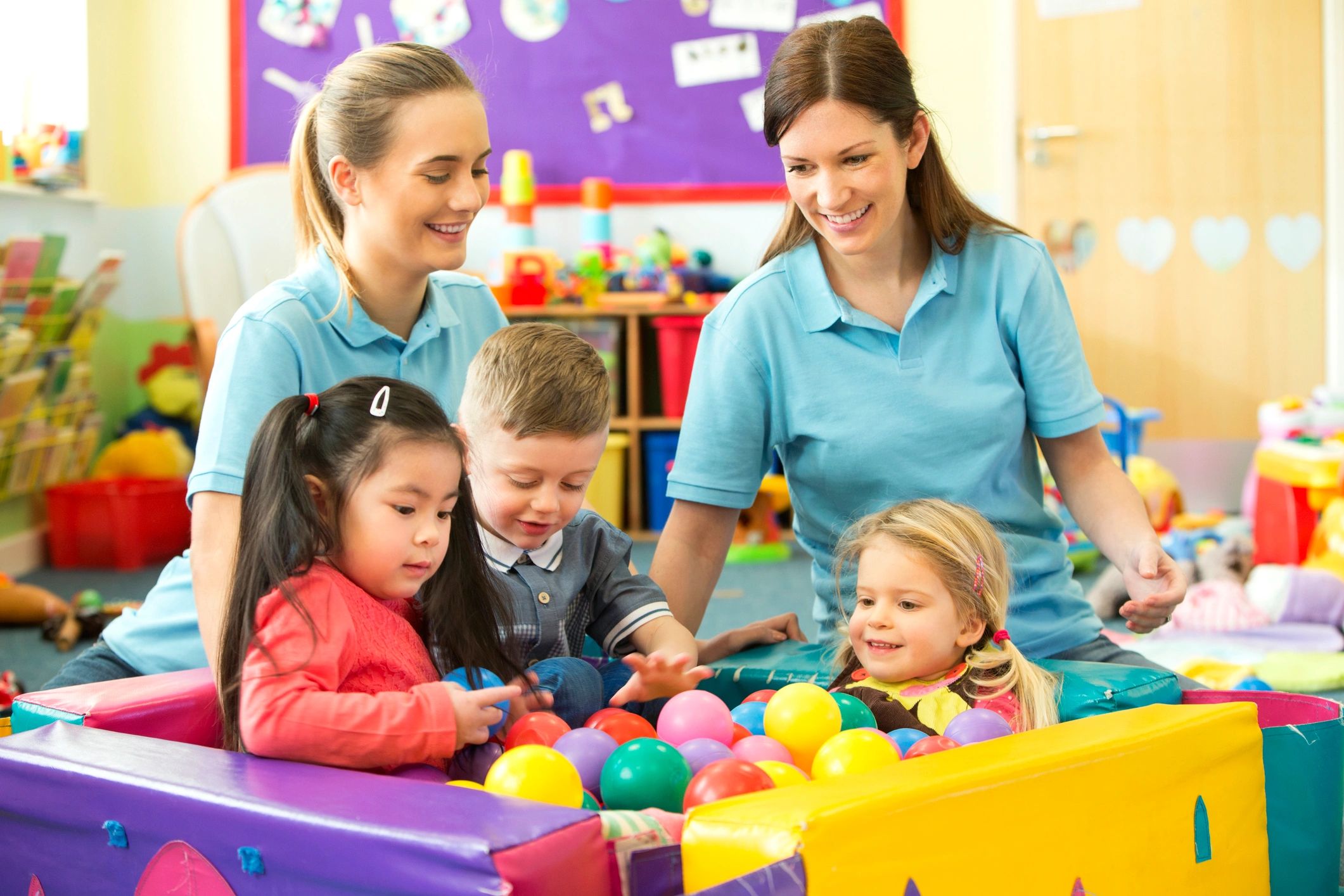 childcare staff helping children